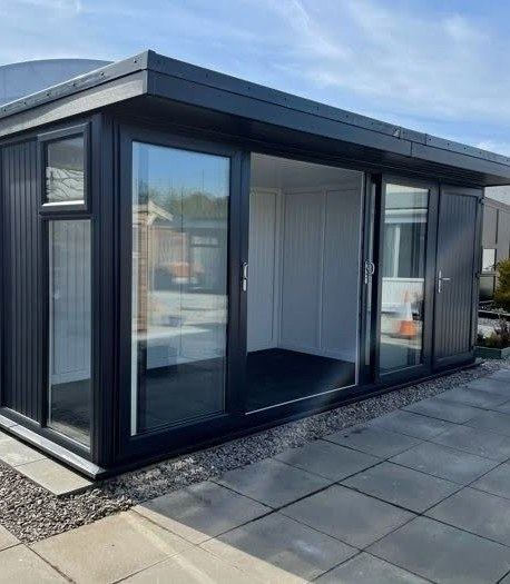 A compact anthracite garden building with a lockable door