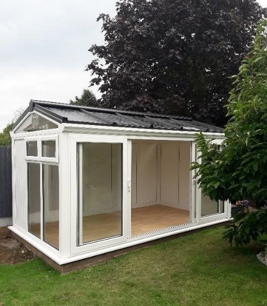 A small white garden building on a lawn